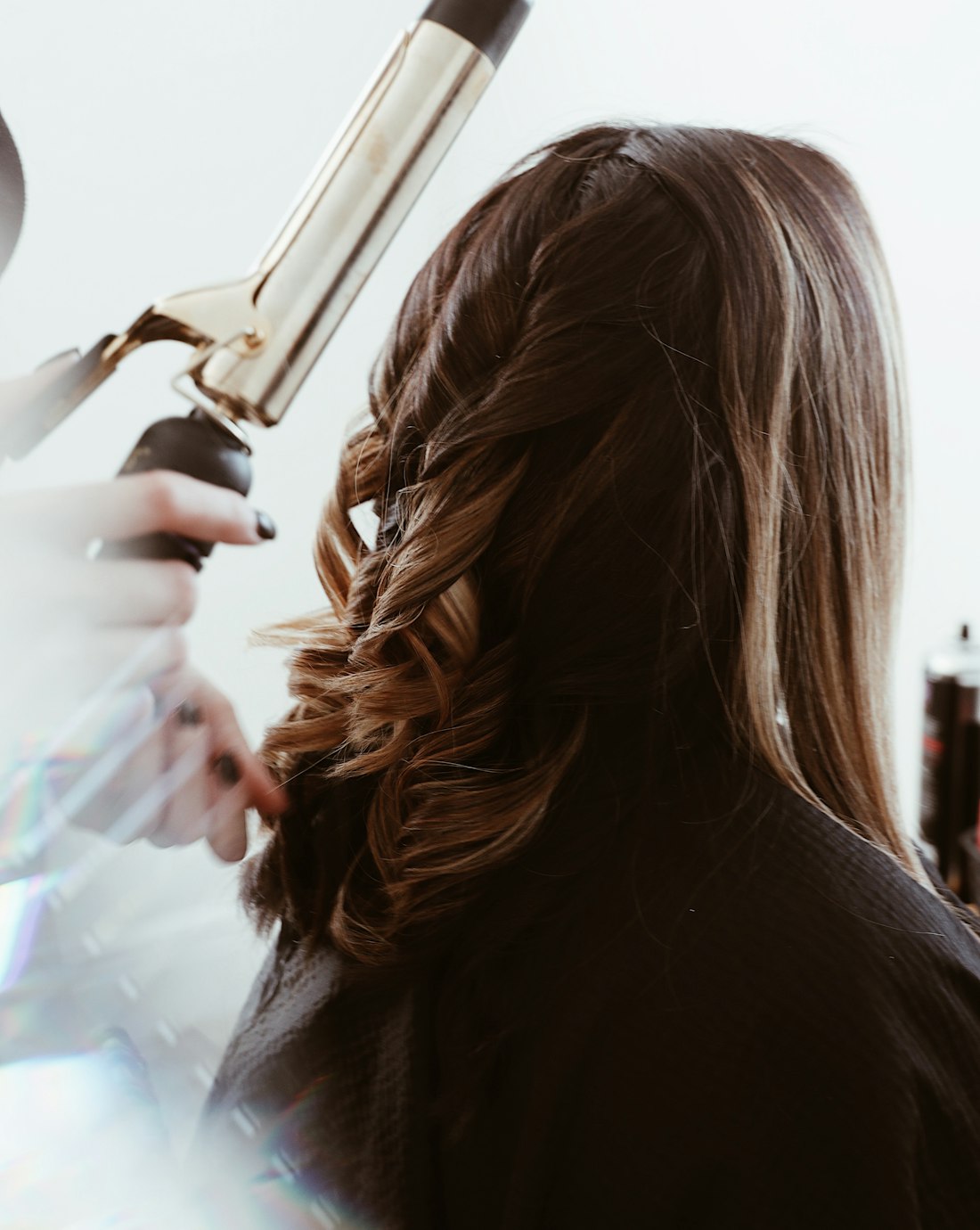 Hands setting a wave through long auburn hair